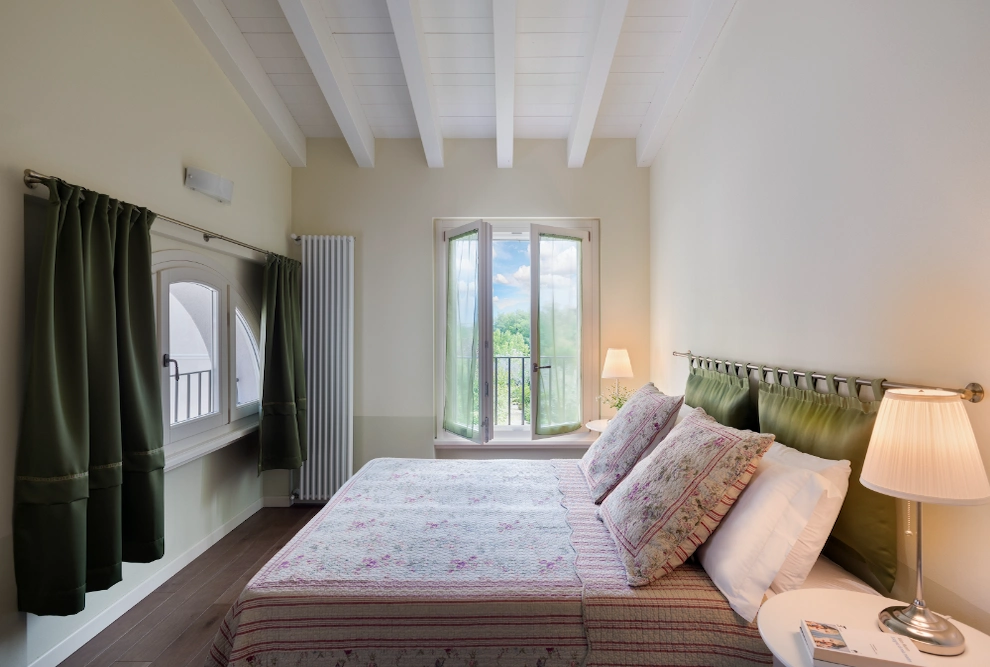 Elegant double bedroom in the one-bedroom apartment at Palazzo Scolari, Polpenazze, featuring a comfortable bed and refined atmosphere for a Lake Garda holiday.
