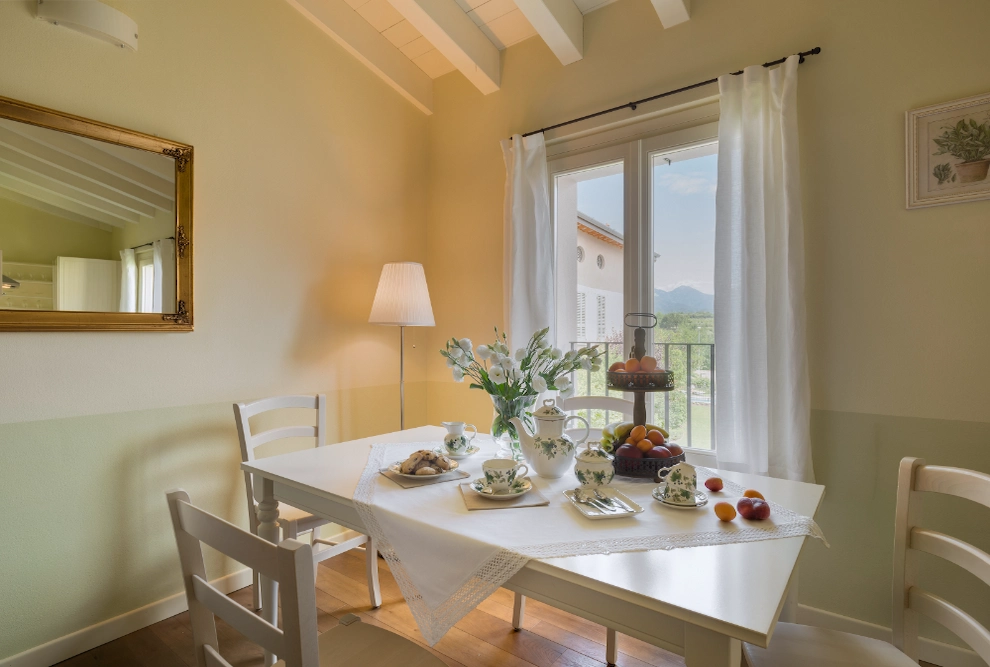 Dining area in the one-bedroom apartment at Palazzo Scolari with a view of the internal garden, perfect for relaxing breakfasts at Lake Garda.