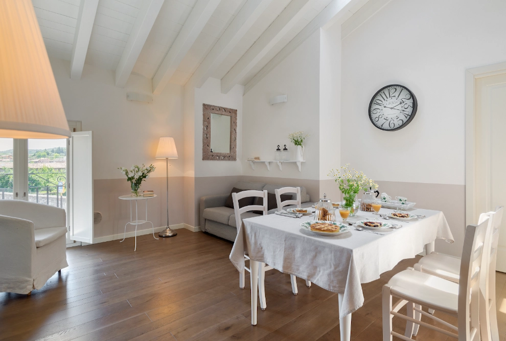 Interni luminosi di un lussuoso appartamento per vacanze a Palazzo Scolari: moderna zona pranzo e zona lounge vicino al Lago di Garda.